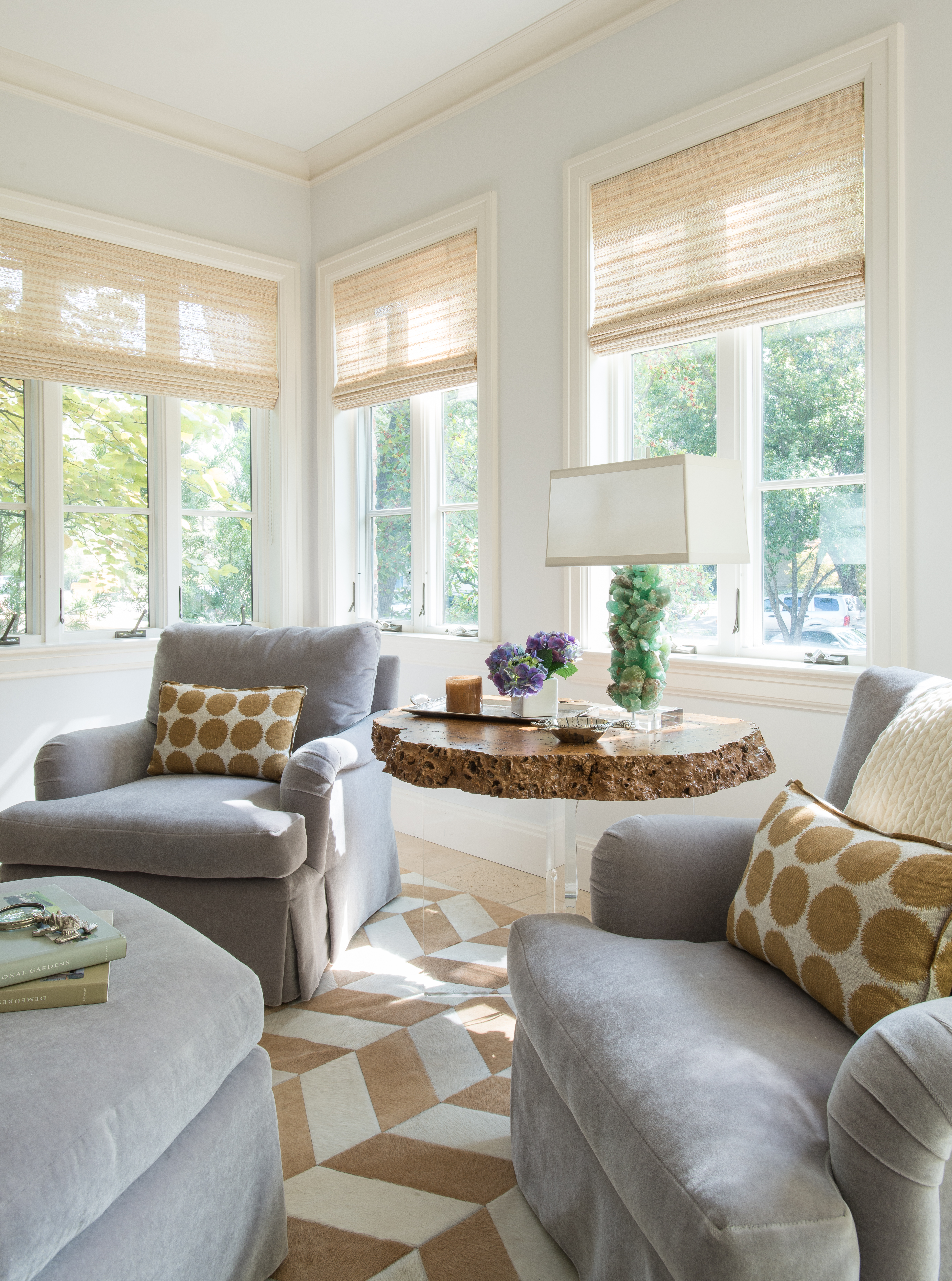 Because the herringbone rug and the polka-dot pillows share a neutral palette, the effect is complementary rather than clashing.
